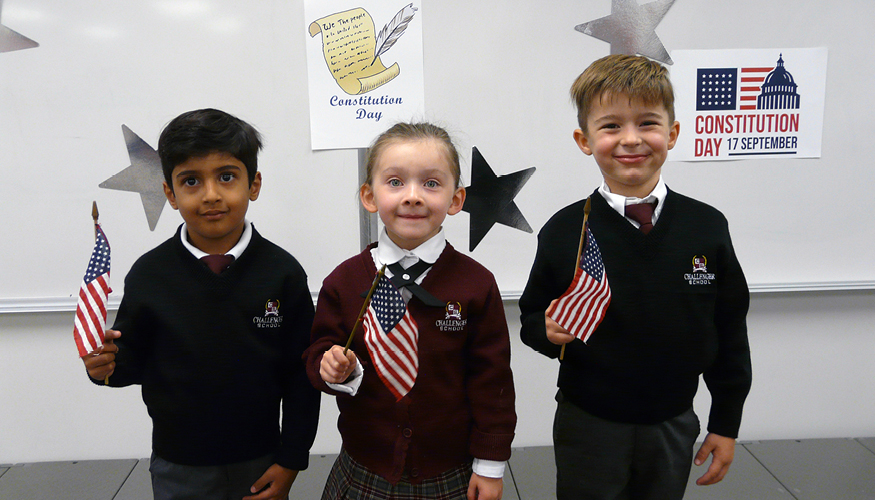 Three young Challenger students holding American flags